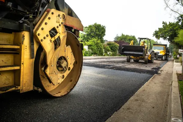 Roller compacting new asphalt on a commercial paving job