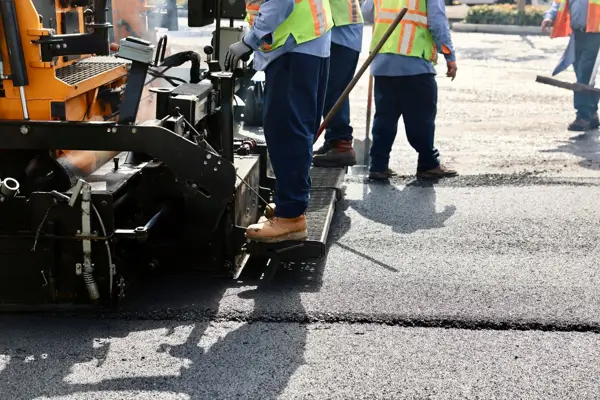 Workers finishing pavement for ADA Title 24 accessibility compliance upgrades